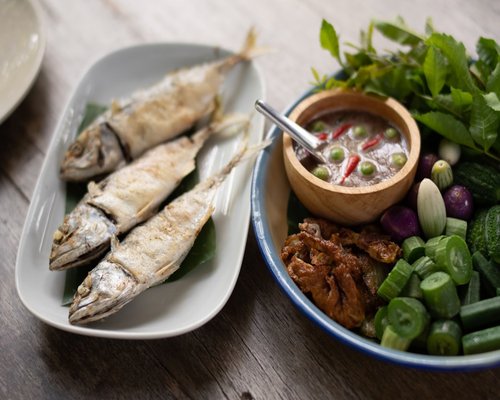 Traditional Thai daily meal with brown rice, fish, and green vegetables